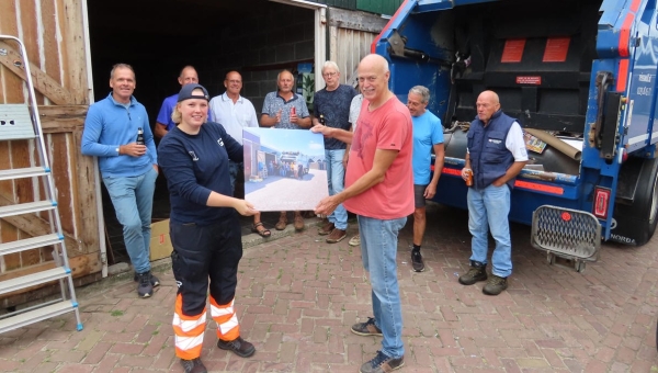 Vrijwilligers papierbox krijgen herinneringsfoto van chauffeuse oud-papier verwerker